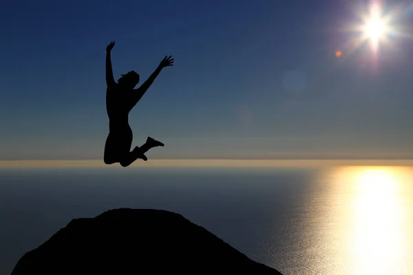 One beautiful silhouette of a girl jumping at sunset — Stock Photo, Image