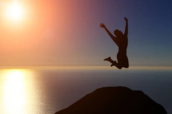 Egy szép sziluettje egy lány jumping naplementekor — Stock Fotó