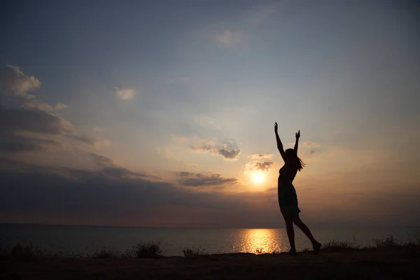 Silhouette girl dancing on the background of a beautiful sunset — Stock Photo, Image