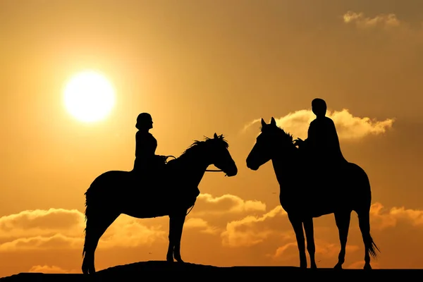 Silhueta de duas pessoas a cavalo fundo de um belo pôr do sol — Fotografia de Stock