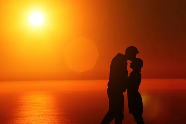 Silhueta cara e menina em um belo pôr do sol de mãos dadas — Fotografia de Stock