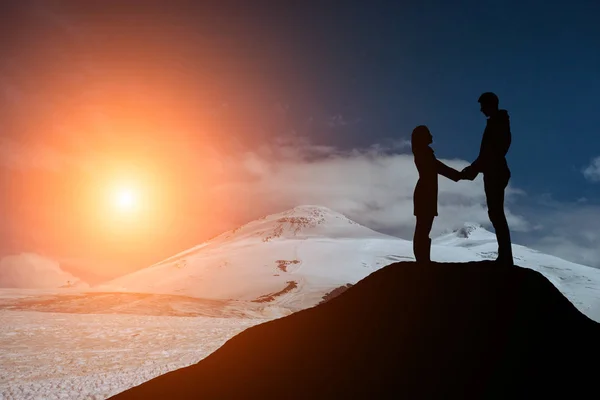 Silhouet jongen en meisje op een mooie zonsondergang hand in hand — Stockfoto