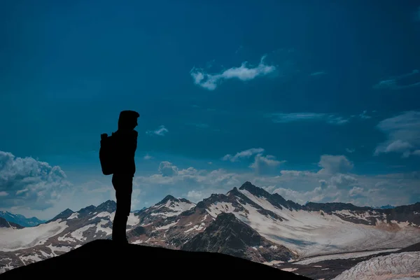 Hombre contra el mar de pie en una cima de la montaña mirando a la distancia — Foto de Stock