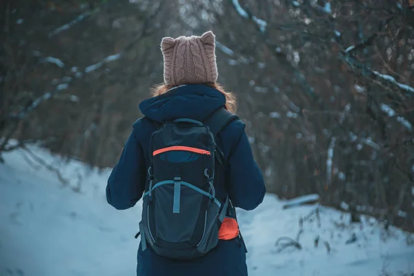 Dziewczynę stojącą w snowy góry Las z plecakiem na drodze w poszukiwaniu — Zdjęcie stockowe