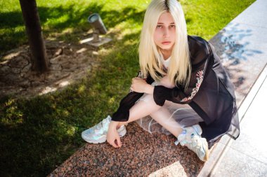 Sarı saçlı bir kız yürüyor. 