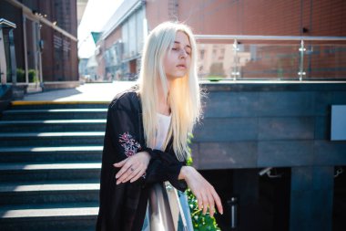 Sarı saçlı bir kız yürüyor. 