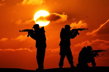 Silhouette of military three soldier or officer with weapons at sunset. shot, holding gun, colorful sky, mountain, background, team clipart