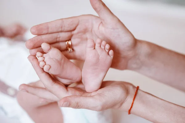 Pasgeboren baby 's voeten op vrouwelijke handen closeup. — Stockfoto