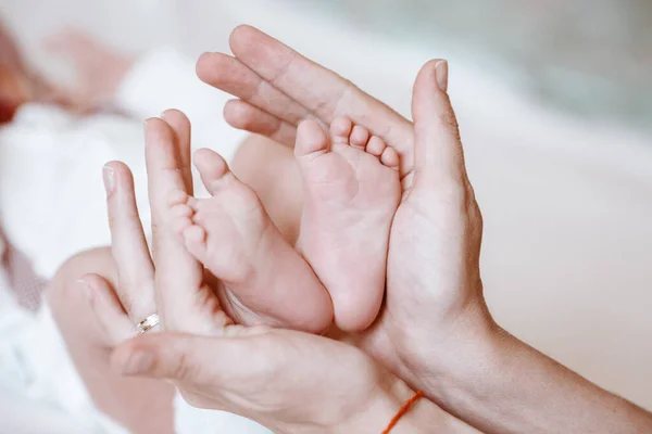 Neugeborenes Baby Füße auf weibliche Hände Nahaufnahme. — Stockfoto