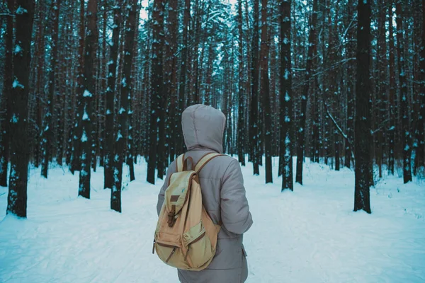 Νεαρός άνδρας στέκεται στο χειμερινό χιονισμένο δάσος — Φωτογραφία Αρχείου