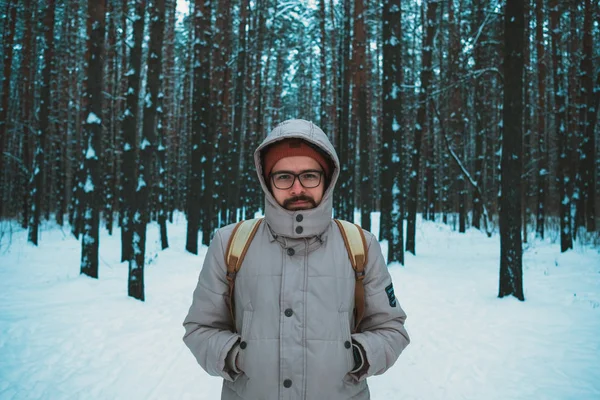 Giovane uomo in piedi nella foresta innevata invernale — Foto Stock