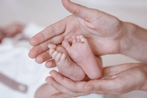 Pasgeboren baby 's voeten op vrouwelijke handen closeup. — Stockfoto