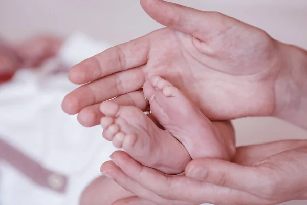 Pasgeboren baby 's voeten op vrouwelijke handen closeup. — Stockfoto