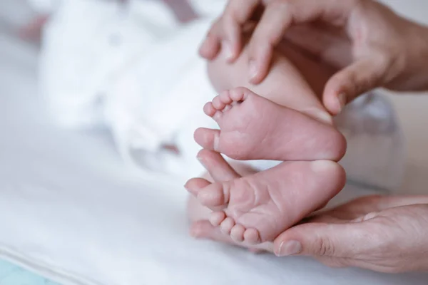 Pasgeboren baby 's voeten op vrouwelijke handen closeup. — Stockfoto