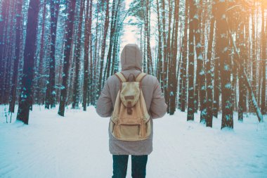 Genç adam kışın karlı ormanında