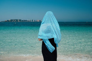 Dubai 'de denizde yürüyen bir kadının arka görüntüsü