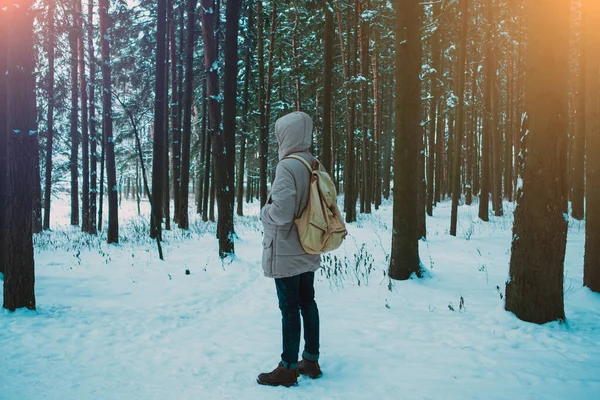 young man in a winter snowy forest