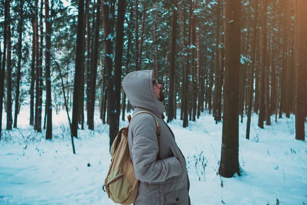 young man in a winter snowy forest