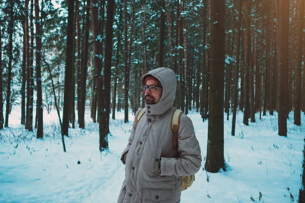 Mladý muž v zimě zasněžený les — Stock fotografie