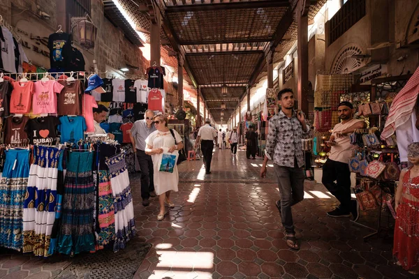 Dubai, Emiratos Árabes Unidos - 6 de marzo de 2017: Tiendas y vendedores en el antiguo zoco textil cubierto Bur Dubai en el centro histórico de la ciudad — Foto de Stock