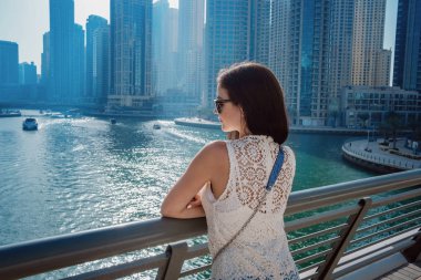 Dubai marinasında mutlu güzel bir turist kadın.