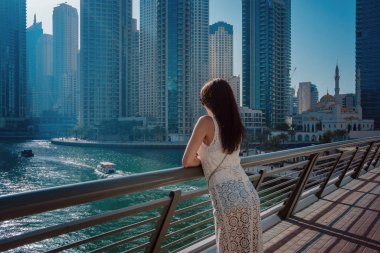 Dubai marinasında mutlu güzel bir turist kadın.