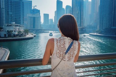 Dubai marinasında mutlu güzel bir turist kadın.