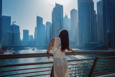 Dubai marinasında mutlu güzel bir turist kadın.