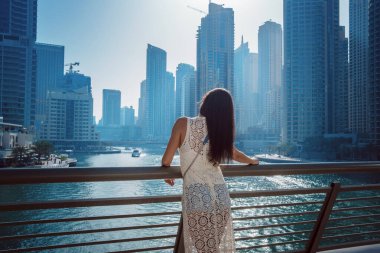 Dubai marinasında mutlu güzel bir turist kadın.
