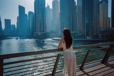 Dubai marinasında mutlu güzel bir turist kadın.