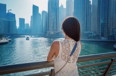 Dubai marinasında mutlu güzel bir turist kadın.