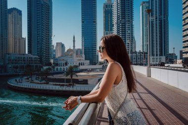 Dubai marinasında mutlu güzel bir turist kadın.