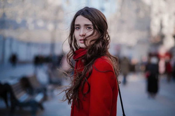 Portré egy fiatal barna nőről piros kabátban egy piros téren Moszkva közepén. — Stock Fotó