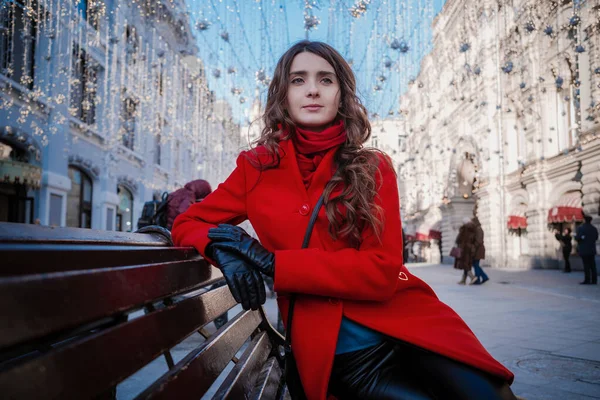 Πορτρέτο μιας νεαρής μελαχρινής γυναίκας με κόκκινο παλτό σε μια κόκκινη πλατεία στο κέντρο της Μόσχας — Φωτογραφία Αρχείου