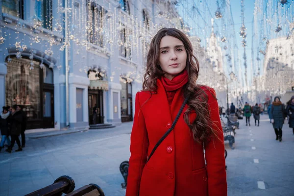 Retrato de una joven morena con un abrigo rojo en una plaza roja en el centro de Moscú —  Fotos de Stock