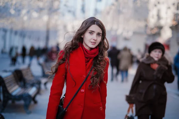 Retrato de una joven morena con un abrigo rojo en una plaza roja en el centro de Moscú —  Fotos de Stock