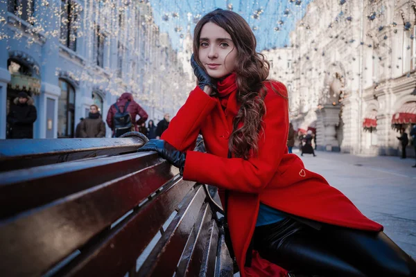 Portré egy fiatal barna nőről piros kabátban egy piros téren Moszkva közepén. — Stock Fotó