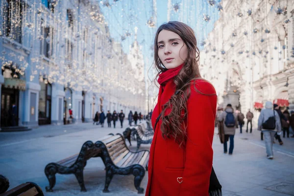 Retrato de uma jovem morena em um casaco vermelho em uma praça vermelha no centro de Moscou — Fotografia de Stock