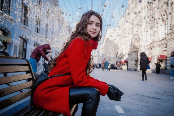 Retrato de uma jovem morena em um casaco vermelho em uma praça vermelha no centro de Moscou — Fotografia de Stock