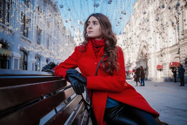 Retrato de uma jovem morena em um casaco vermelho em uma praça vermelha no centro de Moscou — Fotografia de Stock