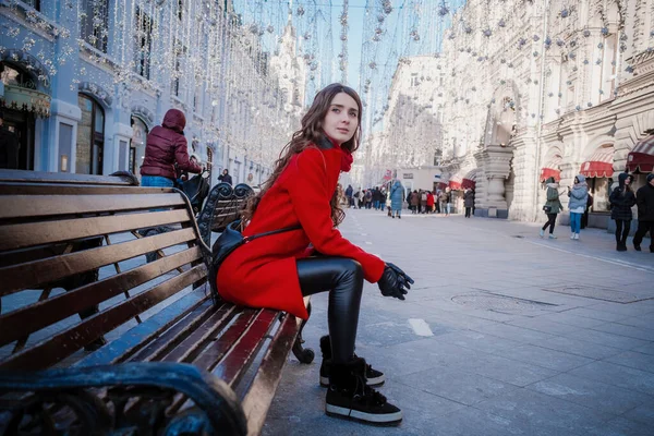 Портрет молодой брюнетки в красном пальто на красной площади в центре Москвы — стоковое фото