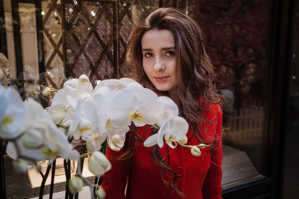 Mulher bonita nova no elegante em um casaco bordô longo, loja indoor — Fotografia de Stock