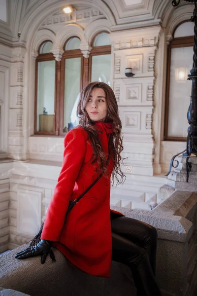 Mulher bonita nova no elegante em um casaco bordô longo, loja indoor — Fotografia de Stock