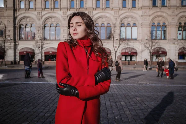 모스크바의 붉은 광장에서 빨간 외투를 입고 걷고 있는 행복 한 여자들 — 스톡 사진