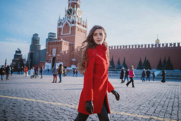 모스크바의 붉은 광장에서 빨간 외투를 입고 걷고 있는 행복 한 여자들 — 스톡 사진