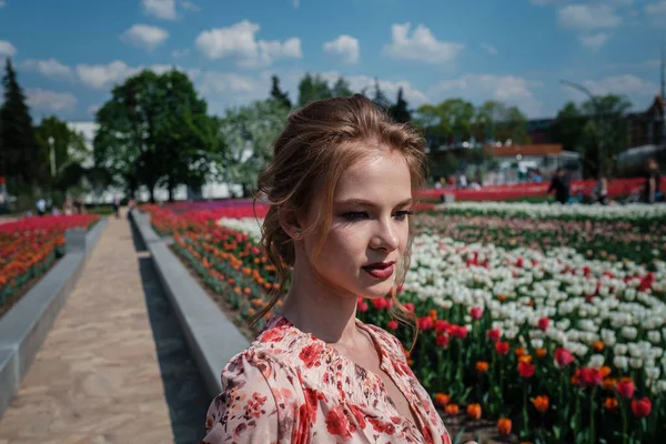 Jovem mulher bonita no campo de tulipas na primavera — Fotografia de Stock
