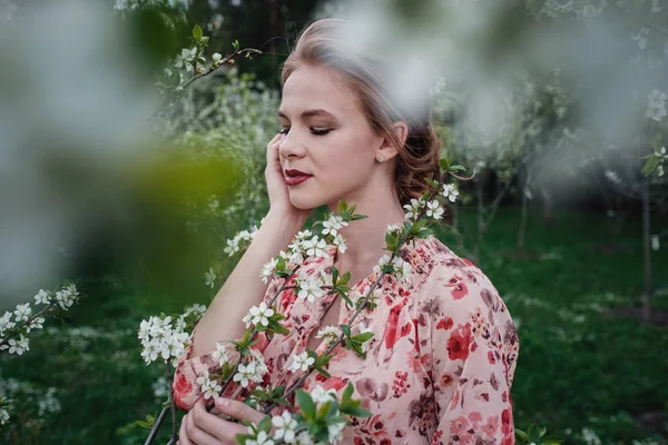 Joven mujer hermosa en el jardín floreciente de cerezos . — Foto de Stock