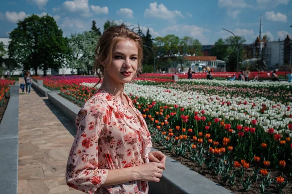 Jovem mulher bonita no campo de tulipas na primavera — Fotografia de Stock