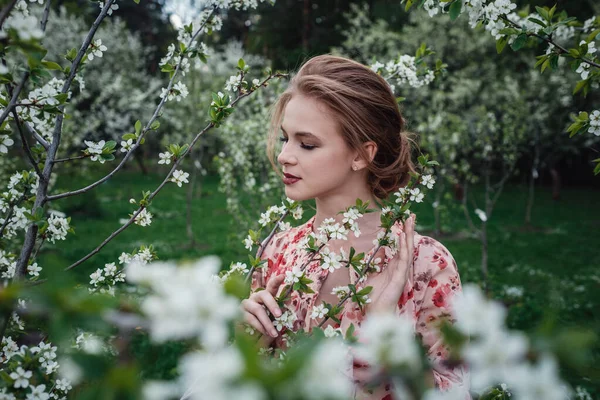 Joven mujer hermosa en el jardín floreciente de cerezos . — Foto de Stock