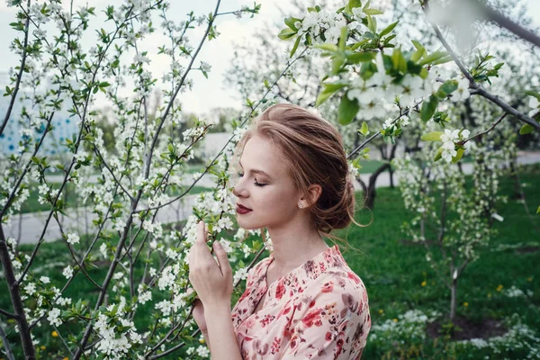 Joven mujer hermosa en el jardín floreciente de cerezos . — Foto de Stock
